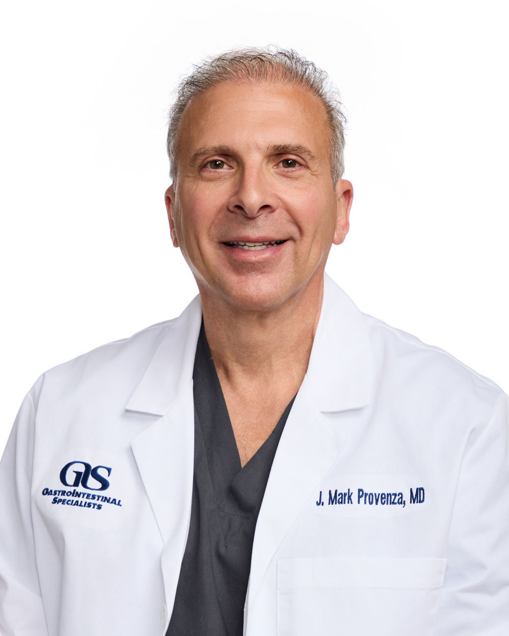 A middle-aged man wearing a white lab coat with "Gastrointestinal Specialists" and "J. Mark Provenza, MD" embroidered on it, standing against a white background.